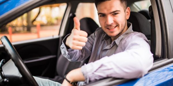 homem-de-sorriso-feliz-que-senta-se-dentro-do-carro-que-mostra-os-polegares-cara-bonito-animado-com-seu-novo-veiculo-expressao-positiva-do-rosto_231208-823.jpg